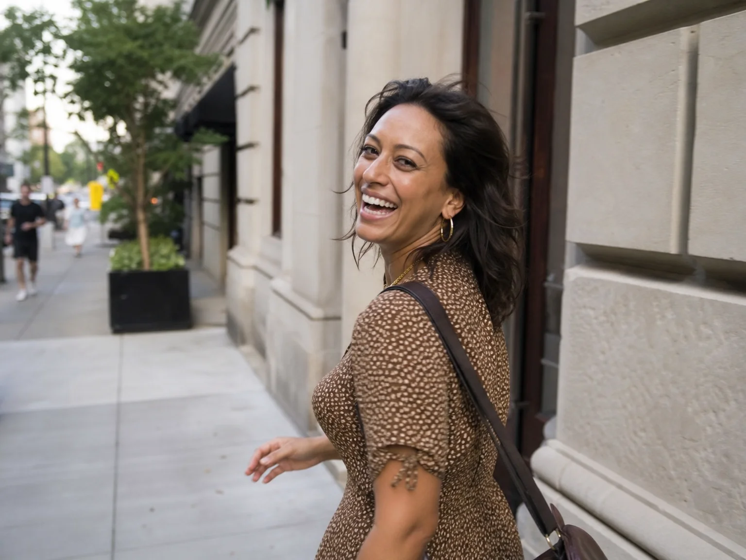 A woman caught mid-laugh while walking, an unposed candid moment captured in burst mode rather than a posed smile