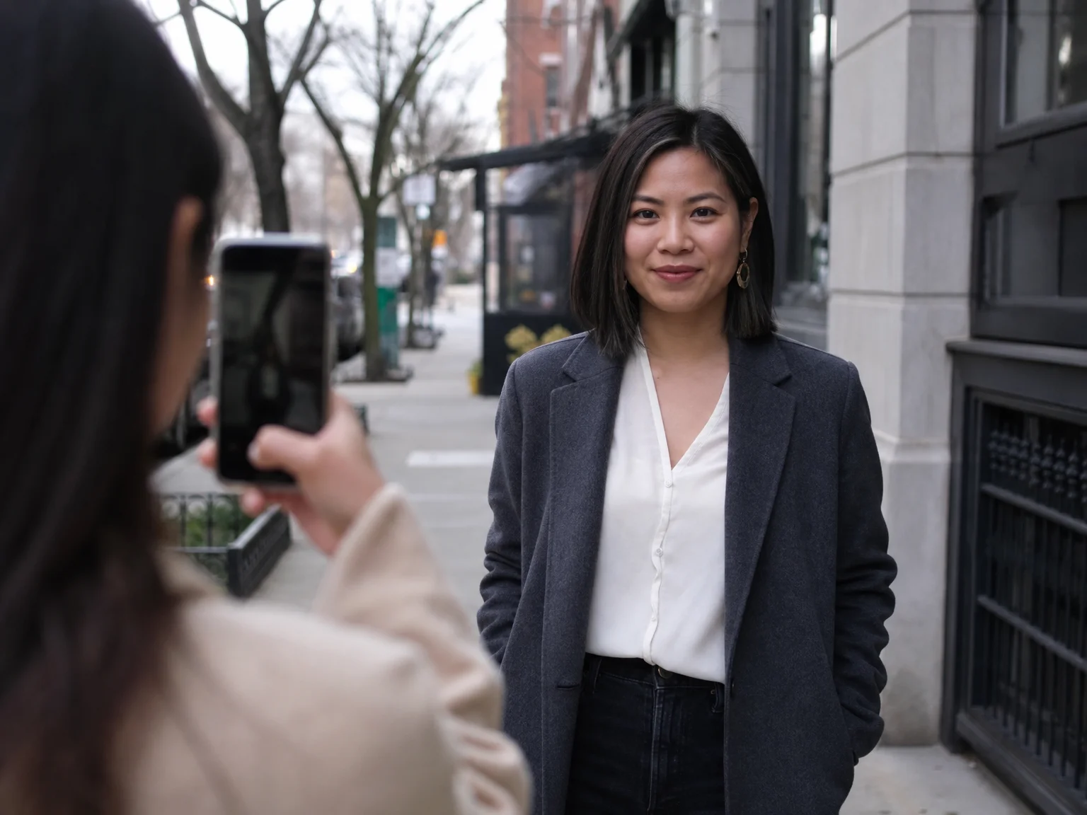 A person holding a phone at the exact eye level of a friend outdoors, demonstrating eye-level portrait framing