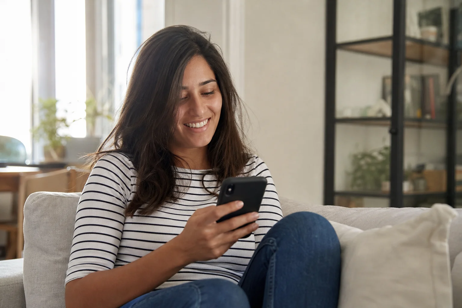 A content creator checks a message on her phone while relaxing at home