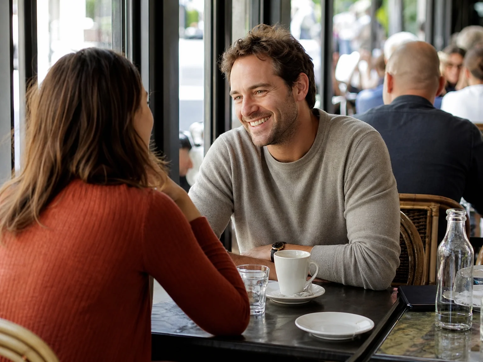 Two people meeting for the first time at a sunny public cafe table